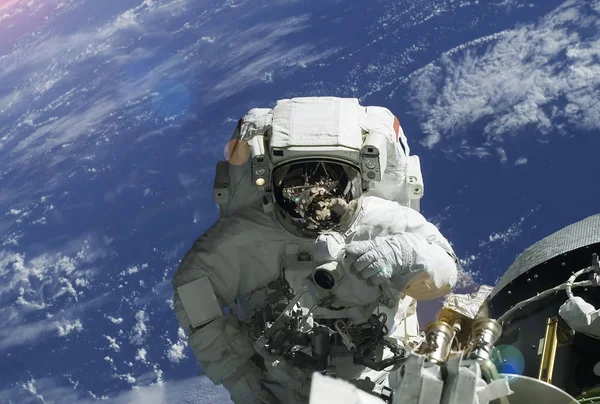 El astronauta en el traje espacial, en el espacio exterior, se ocupa de la reparación de la estación espacial. Elementos de esta imagen fueron proporcionados por la NASA —  Fotos de Stock