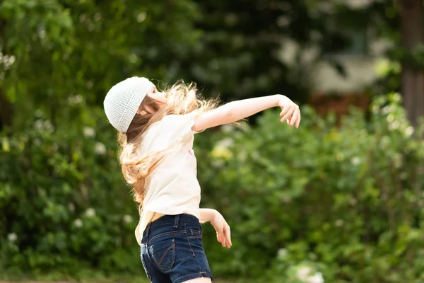 Kleines Mädchen mit langen Haaren spielt Basketball. — Stockfoto