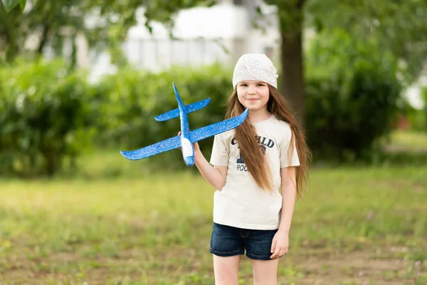 Menina com um avião de plástico de espuma . — Fotografia de Stock