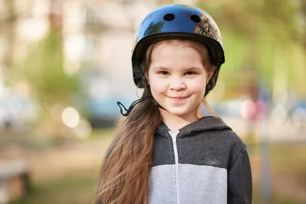 Malá holčička v helmě se usměje velmi roztomile. — Stock fotografie