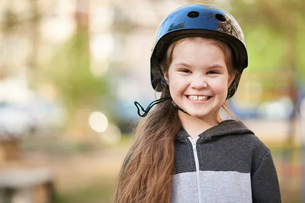 Kleines Mädchen im Helm lächelt lustig. — Stockfoto