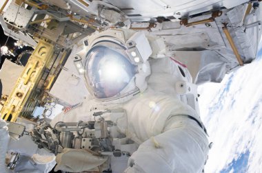 Uzay istasyonunda uzay giysisi giymiş astronot. Bu görüntünün unsurları Nasa tarafından döşenmiştir