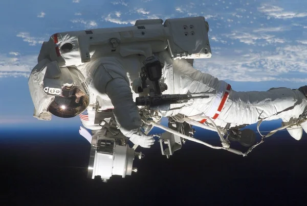 Astronauta en el espacio exterior está disparando a la Tierra. Elementos de esta imagen fueron proporcionados por la NASA — Foto de Stock