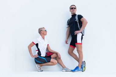 Erkek ve Kadın spor bir bisiklet hafif bir arka plan üzerinde poz giyen.