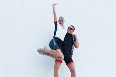 Bir adam bir kadını kollarına aldı, spor kıyafetler, bisiklet kıyafetleri içinde..