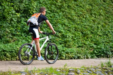 Parkta bisikletli bir adam. Arkadan.