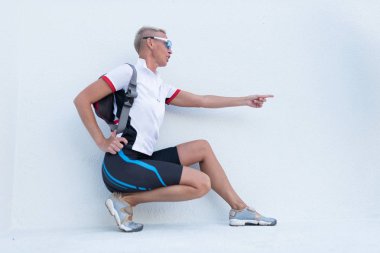 Spor giyimli bir kadın, parmağını sağa doğru işaret etti..