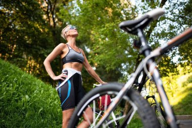 Güzel kadın bir bisiklet arka plan üzerinde poz.