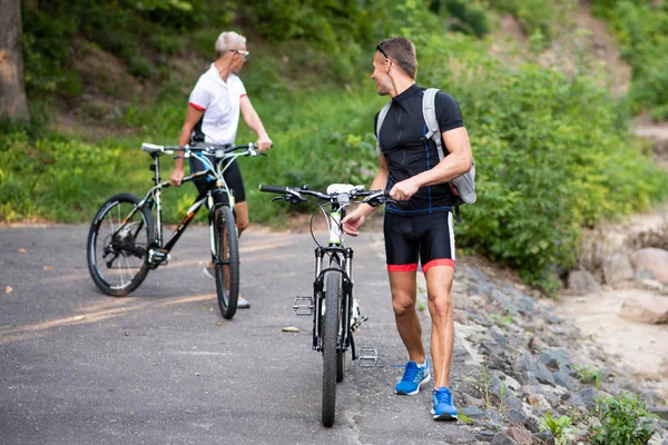 Parkta bir parkta bisikletli bir adam ve bir kadın bir şeye bakıyorlar..