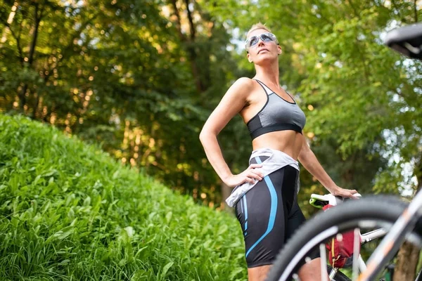 Bisikletle poz veren güzel kadın.