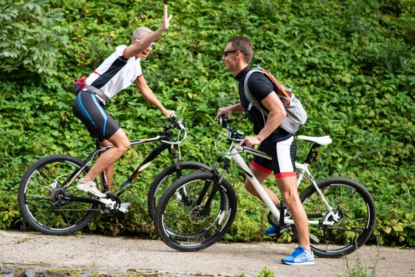 Man and woman on bikes in sportswear. They are going to meet each other.