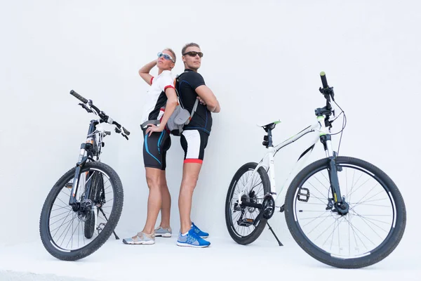 Hafif bir arka plan üzerinde poz bisikletile erkek ve kadın.