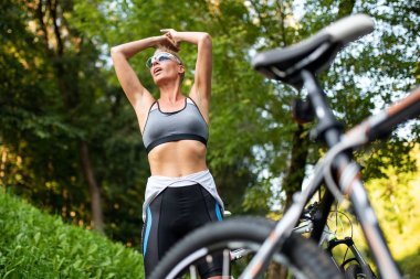 Güzel kadın bir bisiklet arka plan üzerinde poz.