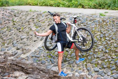 Omzunda bisiklet olan bir adam nehri geçer ve elini uzatır..