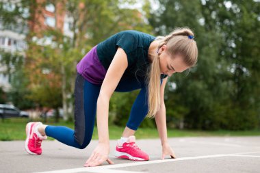 Atletik kız, koşu bandında, başlamak için hazırlanıyor.