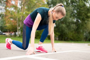 Atletik kız, koşu bandında, başlamak için hazırlanıyor.