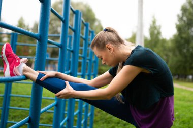 Atletik kız merdiven kompleksinde germe yapıyor.