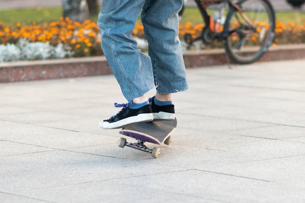 Männerbeine, auf dem Skateboard, mit Tricks. — Stockfoto