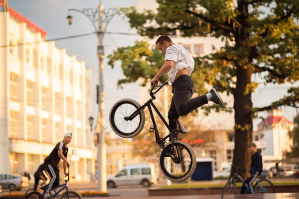 The guy performs a stunt on the BMX, jumping from the parapet high up. — Stock Photo, Image