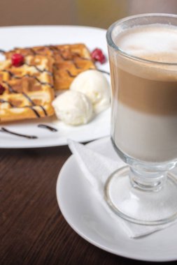 Viyana waffleları ve latte kahve, ahşap bir masada..