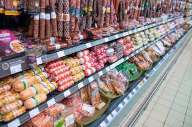 Minsk, Belarus - 27 Eylül 2019: Çeşitli sosisler ve etlerle süpermarket tezgahı