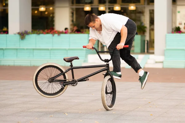 Der Typ auf dem Stuntbike dreht das Rad und macht die Stunts auf dem Vorderrad. — Stockfoto