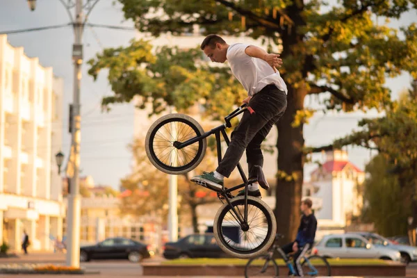 Il tipo fa una acrobazia sulla BMX, saltando dal parapetto in alto . — Foto Stock