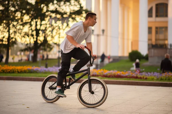 Le gars, debout à pleine hauteur, monte un vélo BMX . — Photo