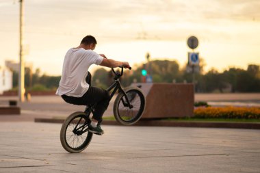 Bmx bisikletli adam arka tekere biniyor..