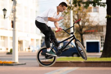 Bmx motorlu genç bir adam, direksiyonu zıplayarak sarıyor..
