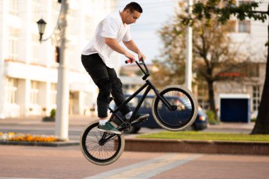 Bmx motorlu genç bir adam, direksiyonu zıplayarak sarıyor..