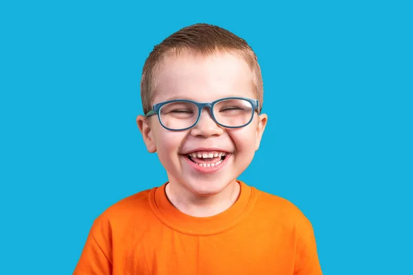 Lacht der kleine Junge mit der Brille. isoliert auf blauem Hintergrund. — Stockfoto