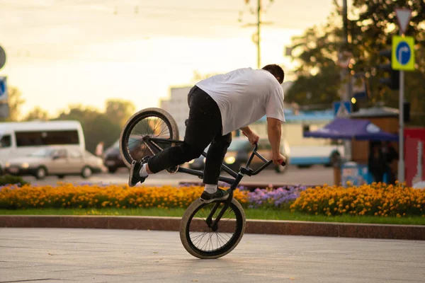 A fickó előad egy mutatványt a Bmx-en, az első keréken áll.. — Stock Fotó