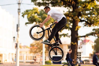Adam Bmx 'e dublörlük yapıyor, yükseğe zıplıyor ve ön tekerleğe dokunuyor..