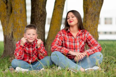 Anne bahçede oğluna yoga öğretiyor..