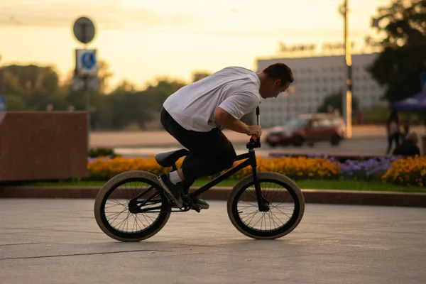 O cara anda de bicicleta BMX ao fundo da rua . — Fotografia de Stock