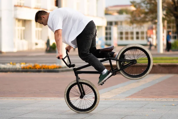 Der Typ auf dem BMX-Rad macht einen Trick am Vorderrad. — Stockfoto