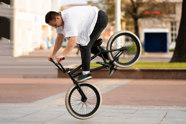 Chlápek na kole Bmx předvádí trik na předním kole. — Stock fotografie