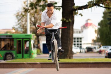 Bmx motorlu genç bir adam, direksiyonu zıplayarak sarıyor..