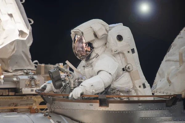 Astronauta en traje espacial. En la estación espacial. Comprometidos en mantenimiento. Elementos de esta imagen fueron proporcionados por la NASA . —  Fotos de Stock