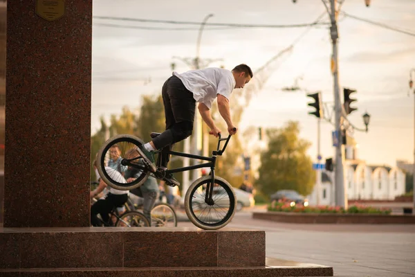 El tipo se para en la rueda delantera del BMX, en el parapeto —  Fotos de Stock