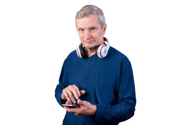 Yaşlı bir adam telefon kullanıyor. Boynunda kablosuz kulaklıkla. Beyaz bir arkaplanda izole edilmiş.