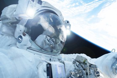 Gezegenin üstündeki açık uzayda bir astronot. Bu görüntünün elementleri Nasa tarafından döşendi.