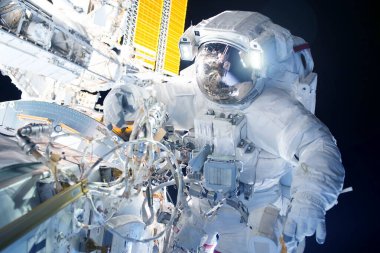 Uzay istasyonundaki astronot tamirat ile meşgul. Bu görüntünün elementleri Nasa tarafından döşendi.