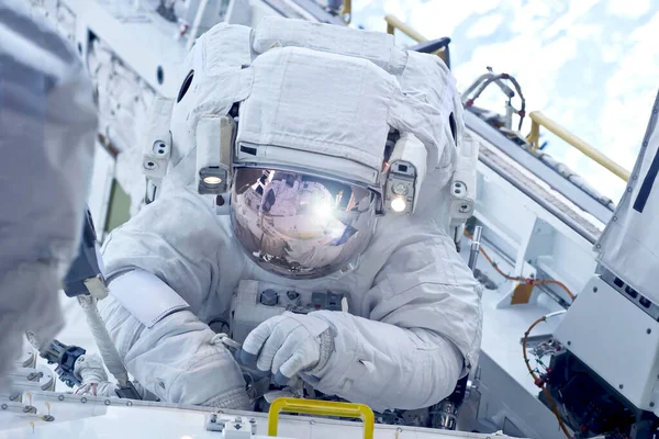 Astronauta en la estación espacial se dedica a reparaciones. Elementos de esta imagen fueron proporcionados por la NASA . —  Fotos de Stock