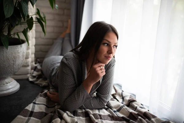 A menina de pijama fica perto da janela . — Fotografia de Stock