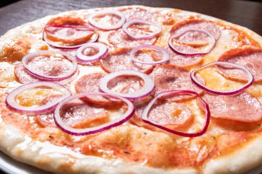 Pepperonili, soğanlı, domates soslu pizza..