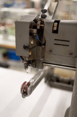 Parçaları düzleştirmek ve bantları yapıştırmak için bir makine. Ayakkabı imalatı.