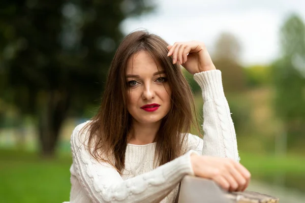 Retrato de uma menina em um banco de parque. — Fotografia de Stock