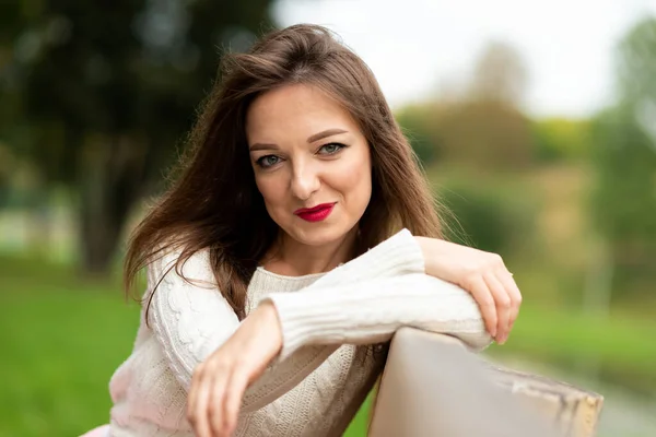 Retrato de uma menina em um banco de parque. — Fotografia de Stock